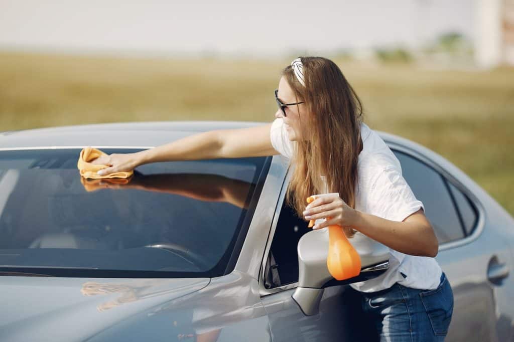 girl cleaning car windshield